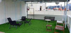 a group of chairs and tables on a room with grass at BluO 1BR Hitech City - Balcony, Gym, Terrace Garden in Hyderabad
