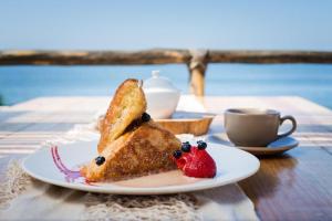 a plate of food with a piece of cake and a strawberry at El Encanto Casa Boutique in Manzanillo