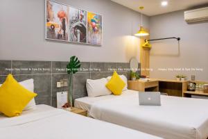 a hotel room with two beds with a laptop on it at Happy Day Hotel & Spa in Danang