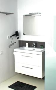 a bathroom with a white sink and a mirror at JINGTU Wellness & Spa B&B in Comares