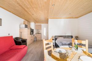 a living room with a red couch and a table at Royal Center in Brides-les-Bains