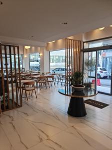 a lobby of a restaurant with tables and chairs at Hotel @Syngrou Fix in Athens