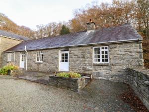 an old stone house with a stone wall at Farchynys Court Cottage in Penmaenpool