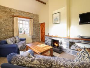 a living room with couches and a fireplace at Farchynys Court Cottage in Penmaenpool