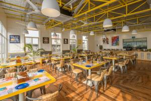 an empty restaurant with wooden tables and chairs at Bedzzz Varanasi by Leisure Hotels, 1 Km from Dashwasamedh Ghat in Varanasi