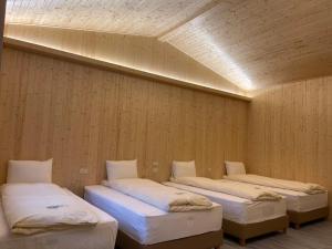 3 camas están alineadas en una habitación en Dong Bi Villa, en Gukeng