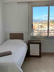a bedroom with two beds and a large window at Estudiotel Heart of Alicante with sea view in Alicante