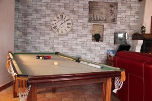a pool table in a living room with a clock at Maison de charme, d'artiste, décoration brocante in Aigrefeuille-dʼAunis