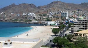 uma vista para uma praia com montanhas ao fundo em Complexo Multiuso Copacabana em Mindelo