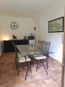 een eetkamer met een glazen tafel en stoelen bij Les Sabots du Parc in Ermenonville