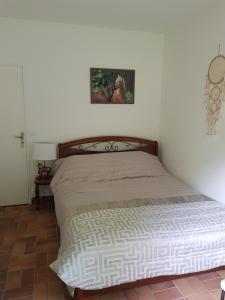 uma cama num quarto com uma fotografia na parede em Les Sabots du Parc em Ermenonville