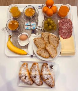 una mesa con dos platos de pan, naranjas y zumo en Sunset Tropea, en Tropea