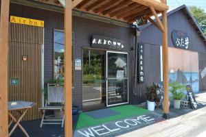 Amakusa - House / Vacation STAY 5358 في أماكوسا: يوجد متجر ذو أرضية خضراء أمام مبنى