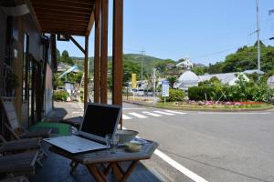 天草市にあるAmakusa - House / Vacation STAY 5358の建物の外のテーブルに座ったラップトップコンピュータ