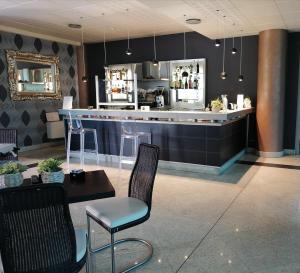 un bar in un ristorante con sedie e un bancone di Hotel Parisi a Nichelino
