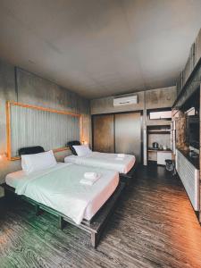 a large bedroom with two beds and a television at BED STOP Hotel Chiangmai in Chiang Mai