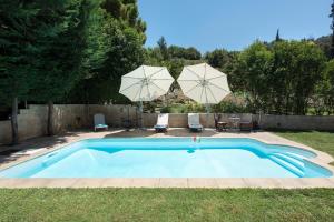 - une piscine dans une cour avec 2 parasols dans l'établissement Spitaki Pool House, à Corfou