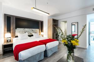 a bedroom with a large bed with a red blanket at Hotel Sevilla in Seville