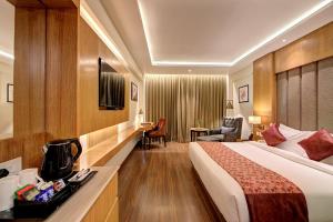 Habitación de hotel con cama grande y escritorio. en Best Western Plus Revanta Mcleod Ganj, en Dharamshala