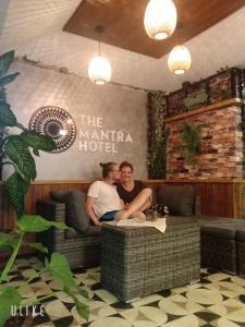 two people sitting on a couch in a restaurant at The Mantra Hotel Kata Noi in Kata Beach