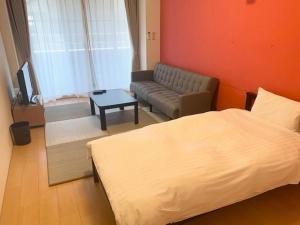 a living room with a bed and a couch at Hamamoto Palace Taniyama - Vacation STAY 11251 in Kagoshima