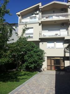 un grand bâtiment blanc avec un balcon et une allée. dans l'établissement Pansion Villa Bubalo, à Mostar