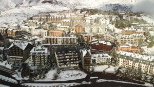 una vista aérea de una ciudad cubierta de nieve en Apartamentos Formigal - admite mascotas, en Formigal