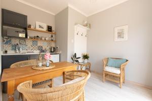 una cucina e una sala da pranzo con tavolo e sedie in legno di Surf Way Beach cottage a Città del Capo
