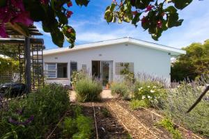 una casa con un giardino davanti di Surf Way Beach cottage a Città del Capo