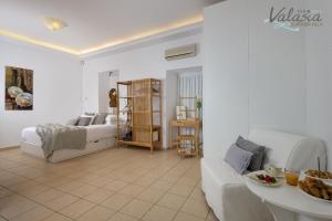 a white living room with a bed and a couch at Panthea Valasia Boutique Villa in Líndos