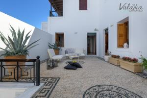 patio ze stołem i krzesłami w budynku w obiekcie Panthea Valasia Boutique Villa w Líndos