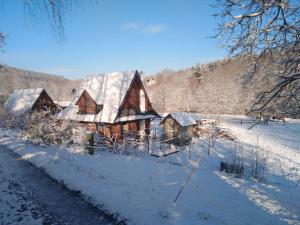 a large wooden house with snow on its roof at Rancho Vaquera in Polanica-Zdrój
