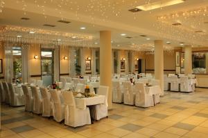 ein Festsaal mit weißen Tischen und Stühlen und Kronleuchtern in der Unterkunft Hotel Leotar in Trebinje