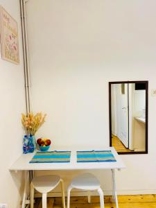 a white table with two chairs and a mirror at Apartment in Ivy covered house, near Old Town in Krakow