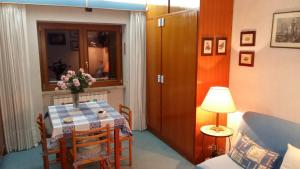 Una habitación con una mesa con un jarrón de flores. en Monolocale Residence Paradiso Aremogna a due passi dagli impianti sciistici, en Roccaraso