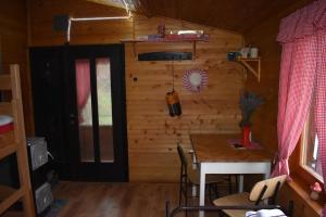 een eetkamer met een tafel en een houten muur bij Odmor za dušu i tijelo u srcu prirode in Aljmaš