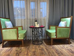 a table with a bottle of wine and two chairs at Hanoi Center Silk Hotel & Travel in Hanoi
