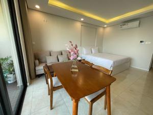 um quarto com uma cama, uma mesa e um sofá em Gavi Home - Luxury Apartment D'Capitale Trần Duy Hưng Hà Nội em Hanói