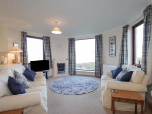 a living room with two couches and a tv at Aurora View in Forres
