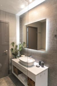 a bathroom with a sink and a large mirror at Amelia Luxury Living in Volos +14 photos