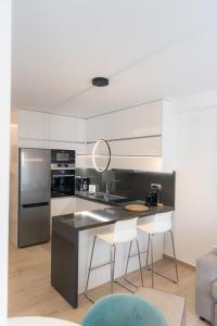 a kitchen with a black counter and white cabinets at Amelia Luxury Living in Volos