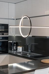 a kitchen with a sink and a mirror on the wall at Amelia Luxury Living in Volos