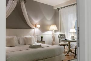 una camera con un letto bianco e un tavolo di B&B Emozioni Fiorentine a Firenze