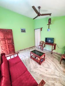 a living room with a red couch and a table at Auslyn Guest House in Bogmolo