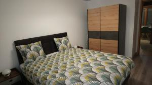 uma cama com um edredão e uma cómoda num quarto em Apart'Bellevue em Morez
