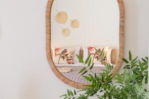 罗希姆诺Effie's cozy old town studios的挂在植物旁墙上的镜子