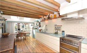 a kitchen with wooden floors and white walls and wooden ceilings at Stylish 3 bed house with parking in Bermondsey, SE1 in London