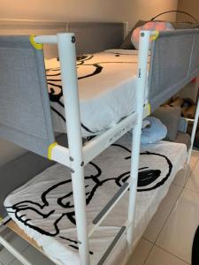 a bunk bed with two white poles on it at Genting Geo38 Residence Snoopy Studio in Genting Highlands