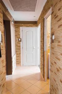 a hallway with a white door and a brick wall at Panorama View Apartment in Veszprém