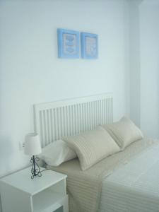 Un dormitorio con una cama y una mesa con una lámpara. en Apartamentos Margoysa I, en Los Alcázares